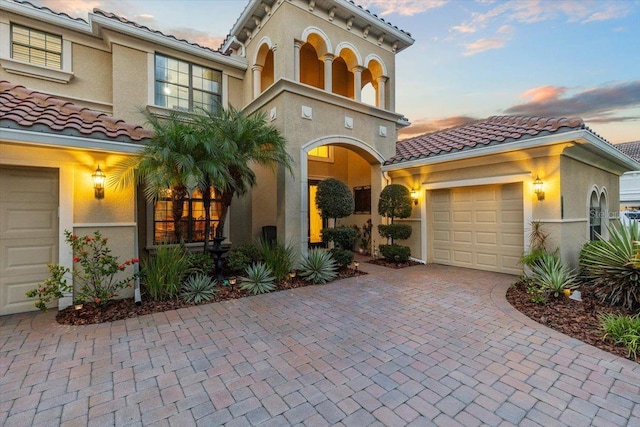 8358 Dunham Station Dr, Tampa, FL 33647 - view of front facade with an attached garage, a tiled roof, decorative driveway, and stucco siding