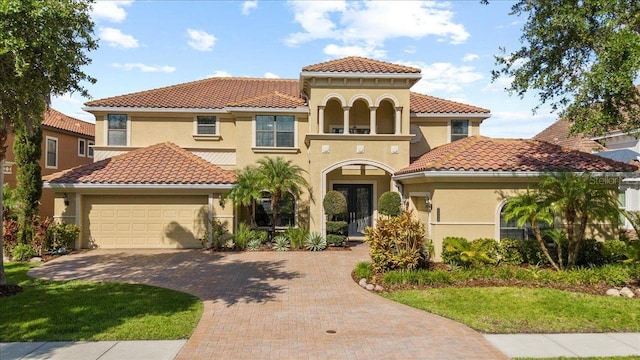 8358 Dunham Station Dr, Tampa, FL 33647 - mediterranean / spanish-style house with a tile roof, an attached garage, stucco siding, and decorative driveway