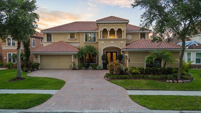 8358 Dunham Station Dr, Tampa, FL 33647 - mediterranean / spanish house with a garage, stucco siding, a front yard, and a tile roof