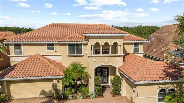 8358 Dunham Station Dr, Tampa, FL 33647 - mediterranean / spanish house with french doors, a tile roof, decorative driveway, an attached garage, and stucco siding