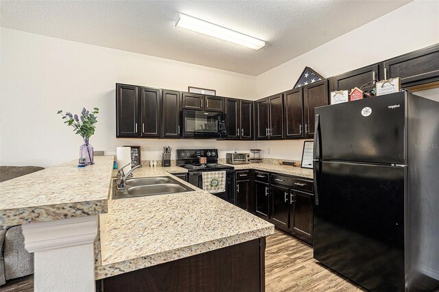 5521 Yellowfin Ct, New Port Richey, FL 34652 - kitchen with black appliances, a peninsula, light countertops, light wood-style floors, and dark brown cabinets