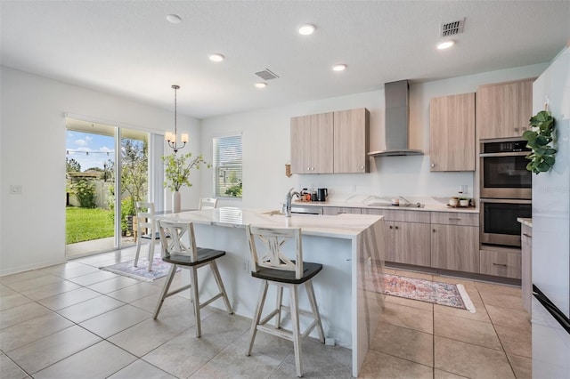 7517 Notched Pine Bnd, Wesley Chapel, FL 33545 - kitchen featuring wall chimney range hood, double oven, light brown cabinets, light countertops, and recessed lighting