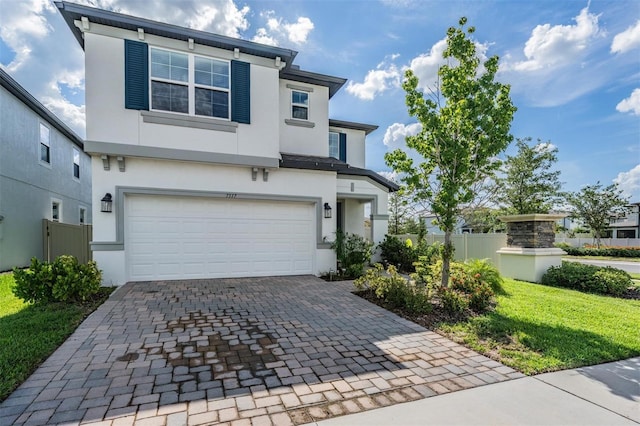 7517 Notched Pine Bnd, Wesley Chapel, FL 33545 - view of front of home with a garage, stucco siding, and decorative driveway