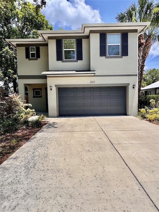 2612 E 26th Ave, Tampa, FL 33605 - traditional home with stucco siding, an attached garage, and concrete driveway
