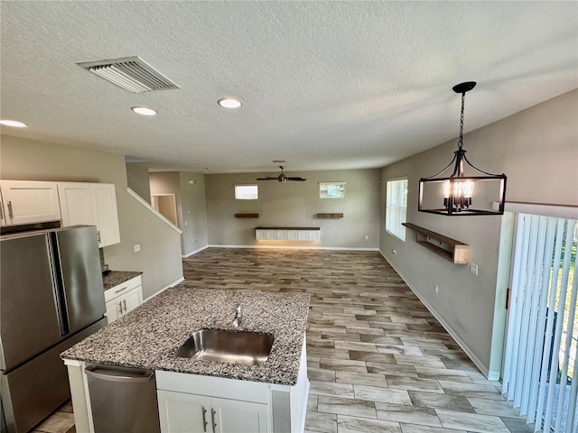 2612 E 26th Ave, Tampa, FL 33605 - kitchen featuring appliances with stainless steel finishes, a ceiling fan, white cabinets, a textured ceiling, and dark stone countertops