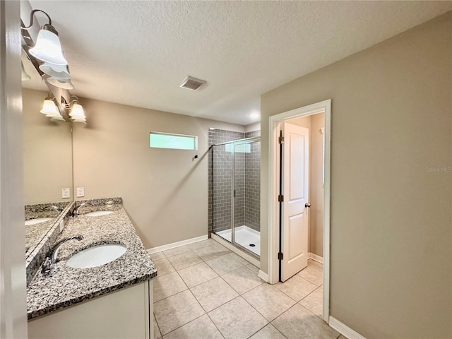 2612 E 26th Ave, Tampa, FL 33605 - bathroom with a shower stall, double vanity, tile patterned floors, and a textured ceiling