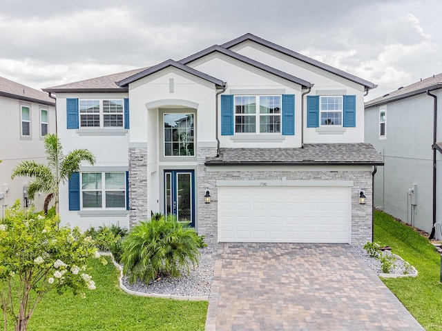 7700 Bronze Oak Dr, Wesley Chapel, FL 33545 - view of front of property with stone siding, an attached garage, stucco siding, decorative driveway, and a front yard