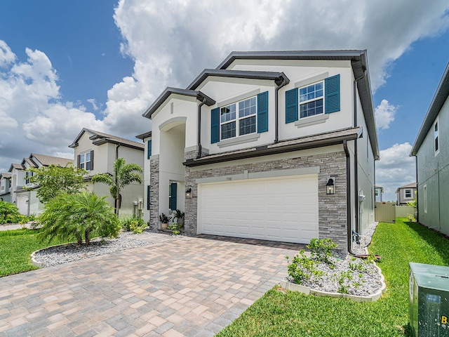 7700 Bronze Oak Dr, Wesley Chapel, FL 33545 - view of front of house featuring stone siding, an attached garage, stucco siding, decorative driveway, and a front lawn