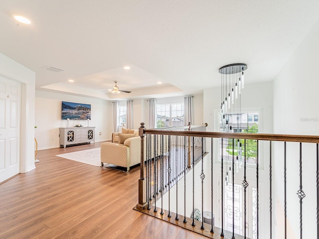 7700 Bronze Oak Dr, Wesley Chapel, FL 33545 - hallway featuring an upstairs landing, wood finished floors, recessed lighting, and a tray ceiling