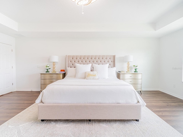 7700 Bronze Oak Dr, Wesley Chapel, FL 33545 - bedroom featuring wood finished floors and a raised ceiling