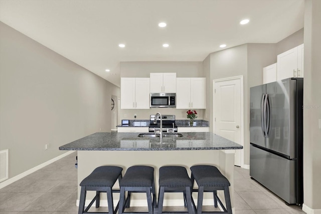 12838 Wildflower Meadow Dr, Riverview, FL 33579 - kitchen with appliances with stainless steel finishes, a kitchen breakfast bar, light tile patterned floors, white cabinetry, and recessed lighting