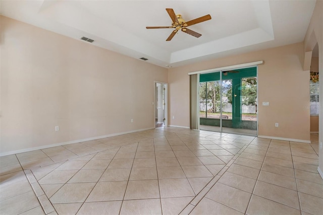 5283 Bevens Ave, Spring Hill, FL 34608 - empty room with a raised ceiling, light tile patterned floors, and a ceiling fan