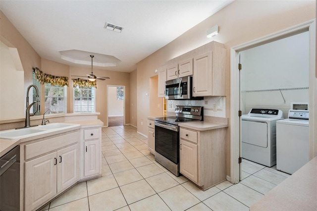 5283 Bevens Ave, Spring Hill, FL 34608 - kitchen featuring appliances with stainless steel finishes, washer and dryer, light tile patterned flooring, and decorative backsplash