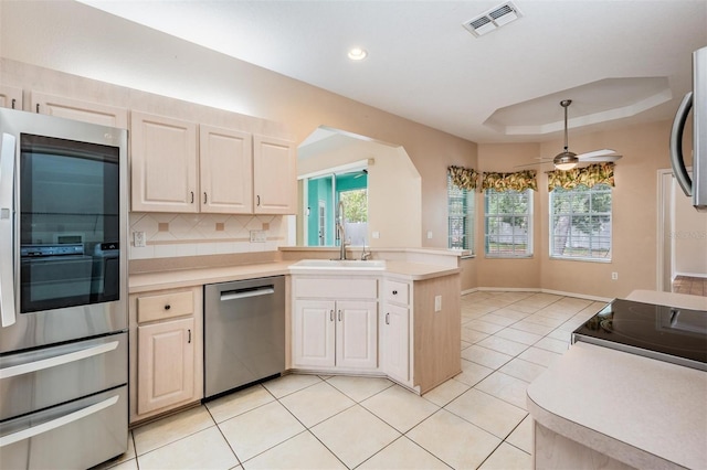 5283 Bevens Ave, Spring Hill, FL 34608 - kitchen featuring appliances with stainless steel finishes, a peninsula, light countertops, backsplash, and light tile patterned floors
