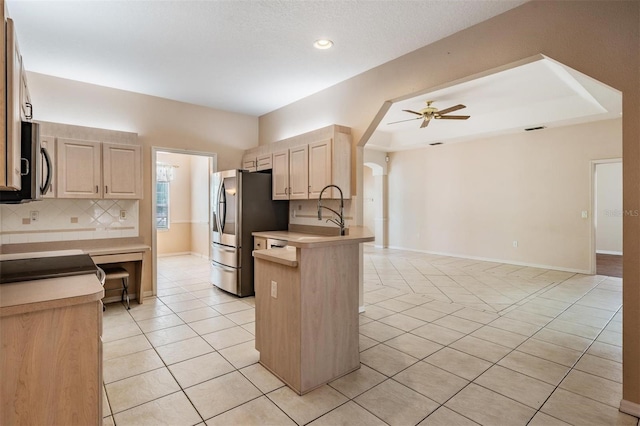 5283 Bevens Ave, Spring Hill, FL 34608 - kitchen with appliances with stainless steel finishes, a ceiling fan, tasteful backsplash, light tile patterned floors, and a peninsula