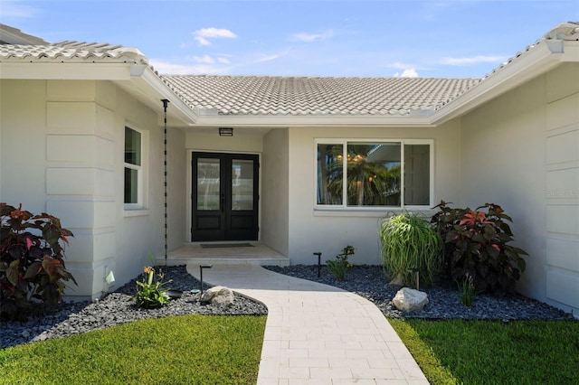 5884 51st St S, Saint Petersburg, FL 33715 - doorway to property featuring a tiled roof, stucco siding, and french doors