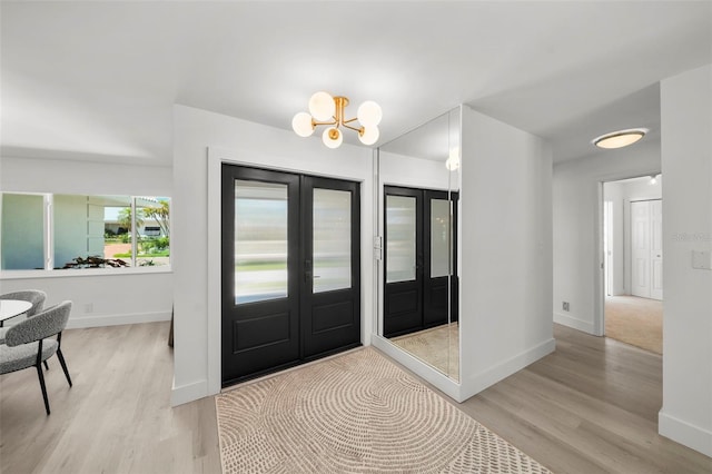5884 51st St S, Saint Petersburg, FL 33715 - foyer entrance with french doors, light wood finished floors, and a chandelier