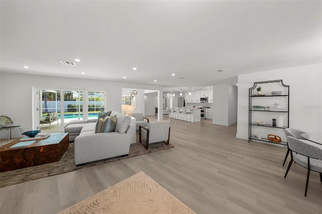 5884 51st St S, Saint Petersburg, FL 33715 - living room featuring light wood finished floors and recessed lighting