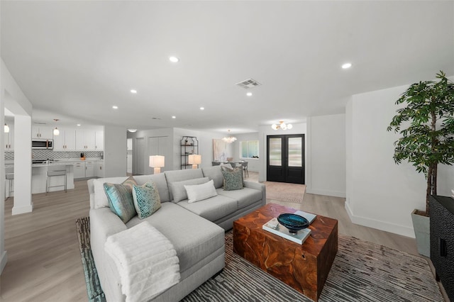 5884 51st St S, Saint Petersburg, FL 33715 - living area with light wood finished floors, recessed lighting, french doors, and a chandelier
