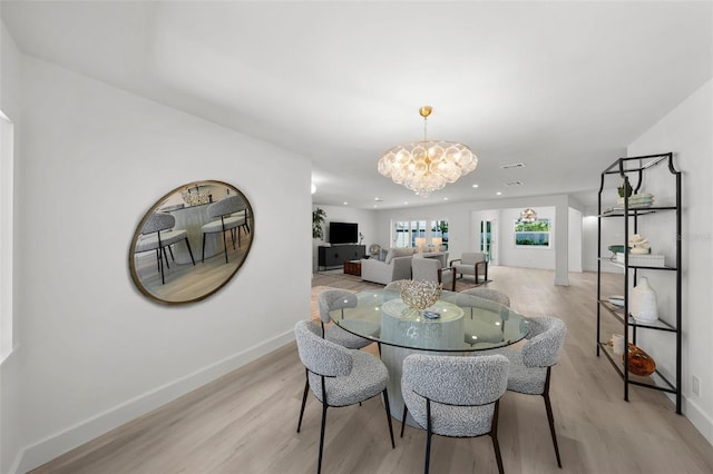 5884 51st St S, Saint Petersburg, FL 33715 - dining area featuring a chandelier and light wood-type flooring