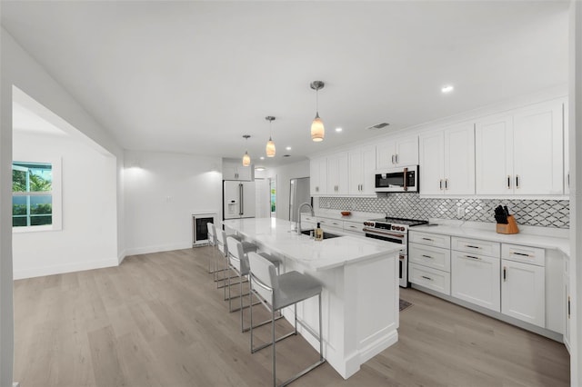 5884 51st St S, Saint Petersburg, FL 33715 - kitchen featuring stainless steel range, tasteful backsplash, light wood-style floors, a breakfast bar area, and recessed lighting