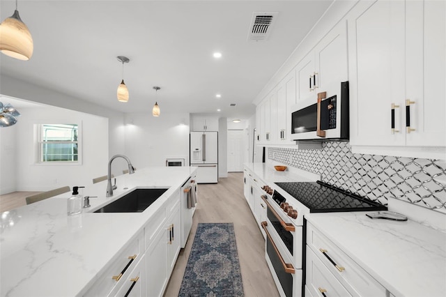 5884 51st St S, Saint Petersburg, FL 33715 - kitchen with white appliances, white cabinets, light wood-type flooring, tasteful backsplash, and recessed lighting