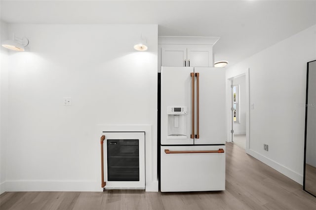 5884 51st St S, Saint Petersburg, FL 33715 - kitchen with white refrigerator with ice dispenser, beverage cooler, light wood finished floors, and white cabinetry
