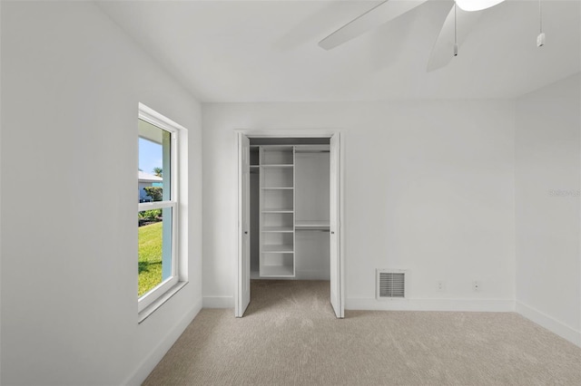 5884 51st St S, Saint Petersburg, FL 33715 - unfurnished bedroom with carpet, multiple windows, ceiling fan, and a closet