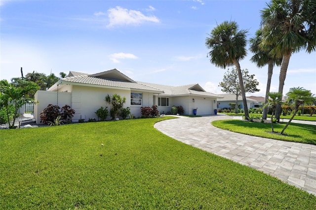 5884 51st St S, Saint Petersburg, FL 33715 - ranch-style house with a garage, decorative driveway, a tiled roof, a front yard, and stucco siding