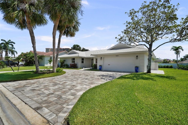 5884 51st St S, Saint Petersburg, FL 33715 - single story home with decorative driveway, an attached garage, a front yard, and stucco siding