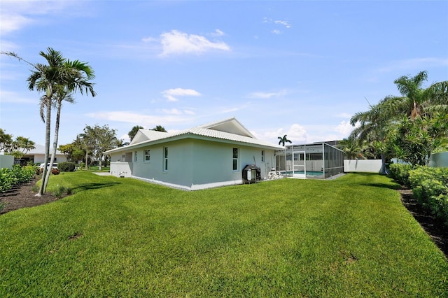 5884 51st St S, Saint Petersburg, FL 33715 - rear view of house featuring a lawn, a lanai, and stucco siding