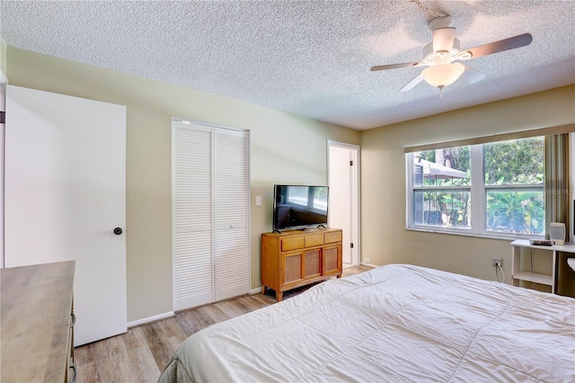 6865 Circle Creek Dr, Pinellas Park, FL 33781 - bedroom featuring a closet, light wood finished floors, a textured ceiling, and a ceiling fan