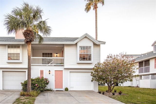 112 Sun Isle Cir Unit 112, Treasure Island, FL 33706 - view of front of property with concrete driveway, a balcony, a garage, and a front yard