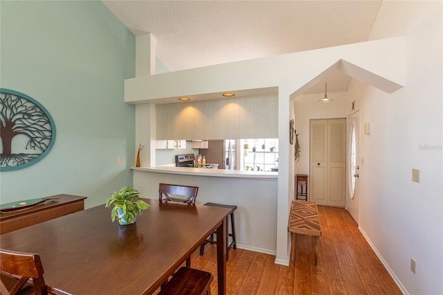 112 Sun Isle Cir Unit 112, Treasure Island, FL 33706 - dining room featuring wood finished floors and vaulted ceiling