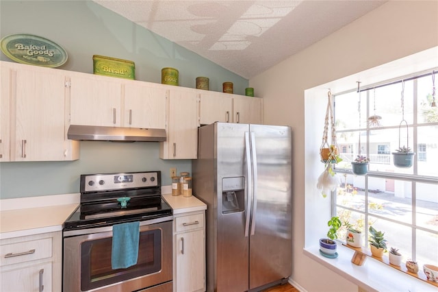 112 Sun Isle Cir Unit 112, Treasure Island, FL 33706 - kitchen featuring appliances with stainless steel finishes, under cabinet range hood, vaulted ceiling, light countertops, and plenty of natural light