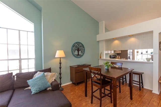 112 Sun Isle Cir Unit 112, Treasure Island, FL 33706 - dining area with light wood-type flooring and high vaulted ceiling