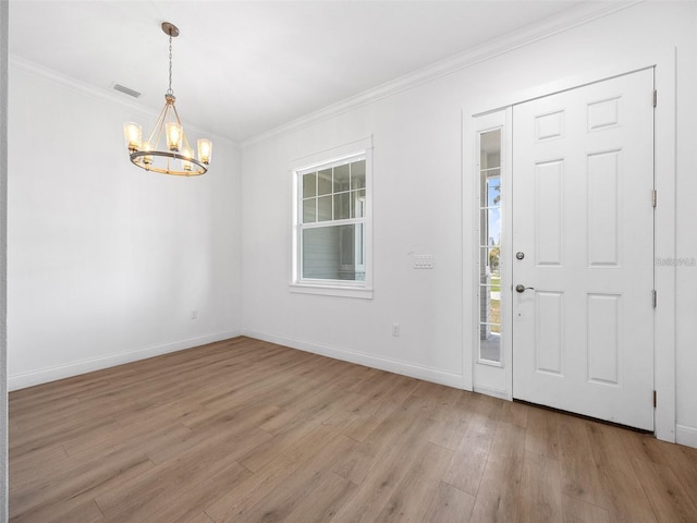 115 White Marsh Ln, Rotonda West, FL 33947 - foyer entrance with a chandelier, light wood-type flooring, and ornamental molding
