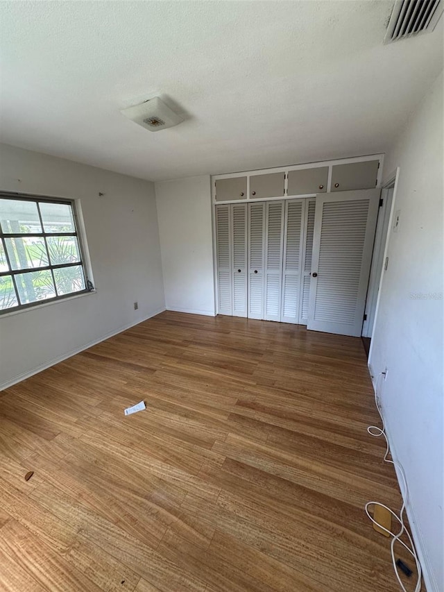 11423 77th Ave, Seminole, FL 33772 - unfurnished bedroom with wood finished floors, a closet, and a textured ceiling