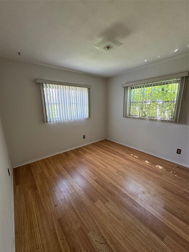 11423 77th Ave, Seminole, FL 33772 - spare room featuring wood finished floors and a textured ceiling