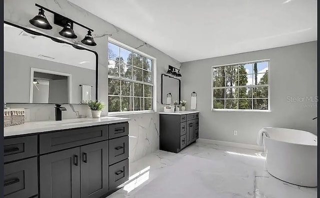 19003 Cedar Ln, Lutz, FL 33548 - full bathroom featuring marble tiled floors, two vanities, and a soaking tub