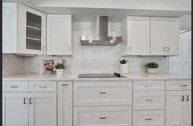 19003 Cedar Ln, Lutz, FL 33548 - kitchen with wall chimney exhaust hood, white cabinets, light countertops, black electric stovetop, and decorative backsplash