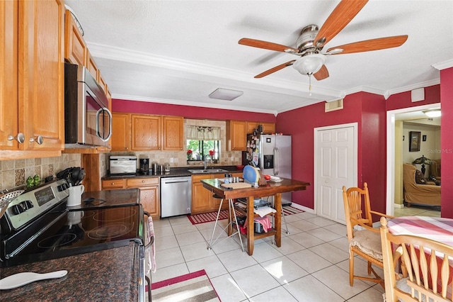 14803 Tulip Dr, Tampa, FL 33613 - kitchen featuring appliances with stainless steel finishes, tasteful backsplash, dark countertops, a ceiling fan, and crown molding
