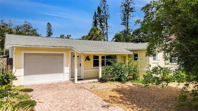 2807 Miriam St S, Gulfport, FL 33711 - ranch-style house featuring an attached garage, stucco siding, decorative driveway, and a shingled roof