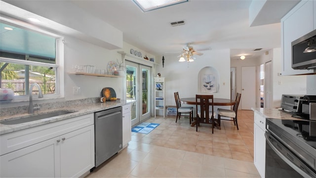 2807 Miriam St S, Gulfport, FL 33711 - kitchen featuring appliances with stainless steel finishes, healthy amount of natural light, white cabinets, and light stone counters