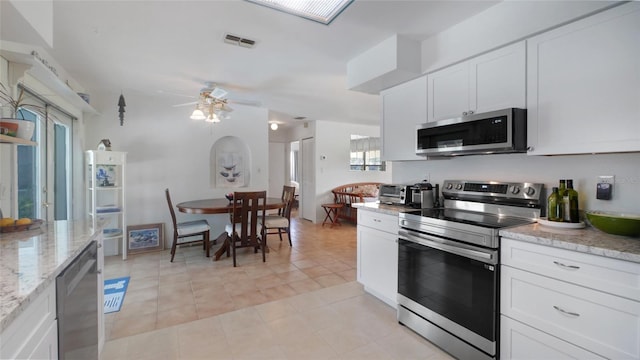 2807 Miriam St S, Gulfport, FL 33711 - kitchen with appliances with stainless steel finishes, white cabinets, ceiling fan, light stone counters, and light tile patterned flooring