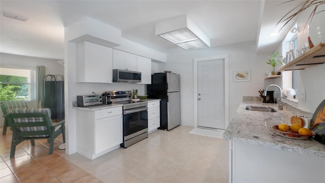 2807 Miriam St S, Gulfport, FL 33711 - kitchen featuring stainless steel appliances, white cabinets, open shelves, and light stone countertops