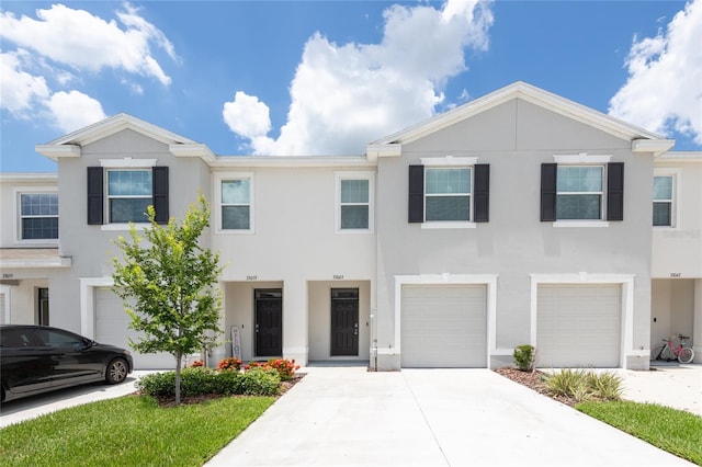 33063 Tulip Petal Ln, Wesley Chapel, FL 33545 - townhome / multi-family property featuring a garage, stucco siding, and driveway