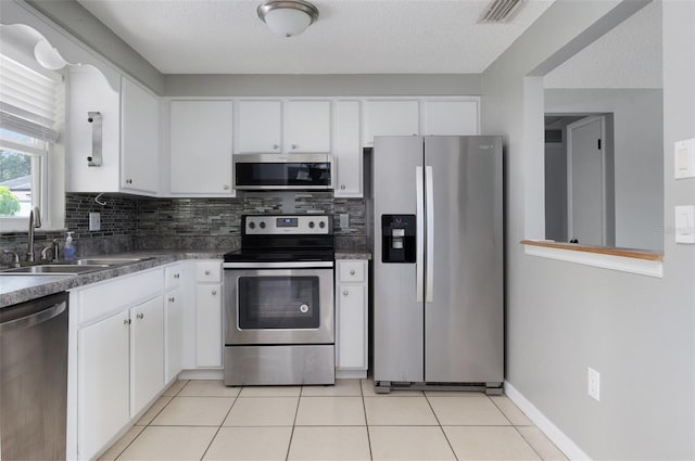 1806 11th St SW, Largo, FL 33778 - kitchen featuring stainless steel appliances, white cabinets, and backsplash