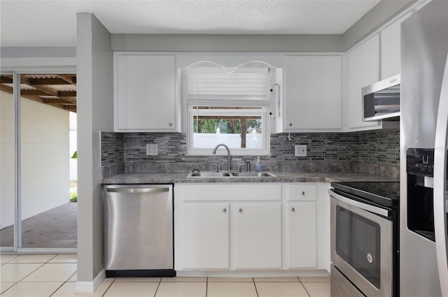 1806 11th St SW, Largo, FL 33778 - kitchen with stainless steel appliances, white cabinetry, light tile patterned floors, and decorative backsplash