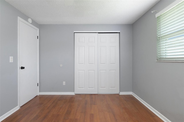 1806 11th St SW, Largo, FL 33778 - unfurnished bedroom with wood finished floors, a closet, and a textured ceiling